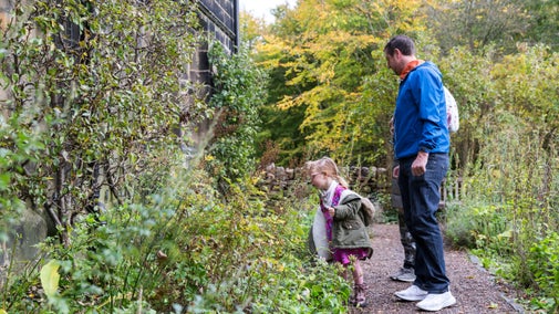 Family exploring the herb garden at East Riddlesden Hall, West Yorkshire